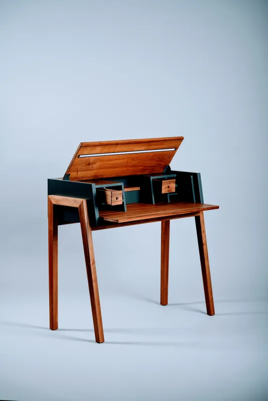 Ein Sekretär, der klassische Ästhetik mit moderner Funktionalität vereint. Durch raffinierte Klappen bleibt die Optik im geschlossenen Zustand minimalistisch und elegant, während im geöffneten Zustand eine perfekt organisierte Arbeitsfläche entsteht. Die zeitlose Formsprache und durchdachte Details machen ihn zum idealen Möbelstück für den modernen Büroalltag.