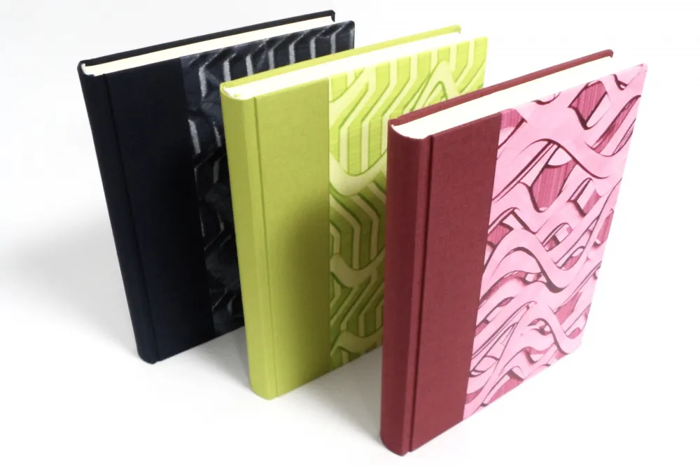Foto: Katja Sauerbier Drei Gästebücher mit Feinleinen und Kleisterpapier bezogen.