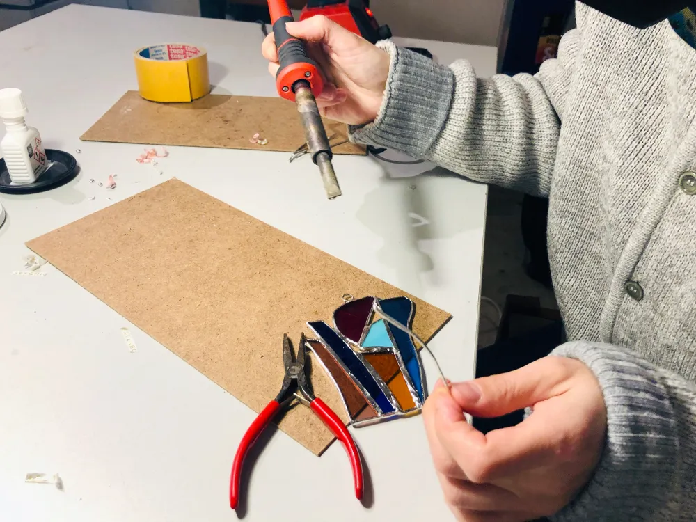 Teilnehmerin eines Glasworkshops beim Löten