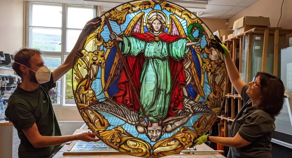 Fensterrose Schlosskirche Neustrelitz, der Erzengel Michael Prächtig leuchtende Kirchenfenster, Bleiverglasung und Glasmalerei: Der Hl. Michael, triumphierend über Satan. Schlosskirche Neustrelitz.